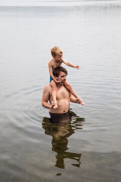 Dad carrying his son on his shoulders in the water