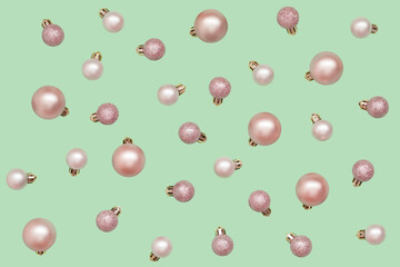 Pink Christmas balls isolated on light green background