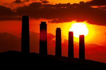 chaminés de fábrica em silhueta ao pôr-do-sol 