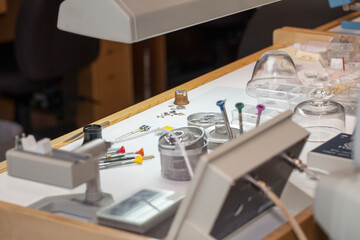 Watchmakers tools and watch parts on the workbench. 