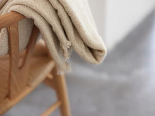 Folded plaid on back of wooden chair