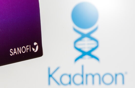 The Sanofi logo is seen on a box of their product in front of a displayed Kadmon logo in this illustration