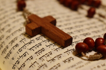 Drewniany krzyżyk na hebrajskim tekście biblijnym - obrazy, fototapety, plakaty