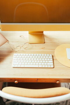 Bamboo desk with glasses, keyboard and mouse pad on top