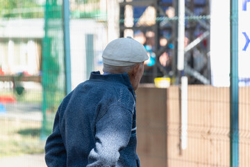 An elderly man walks in the park. Retired in a summer park.