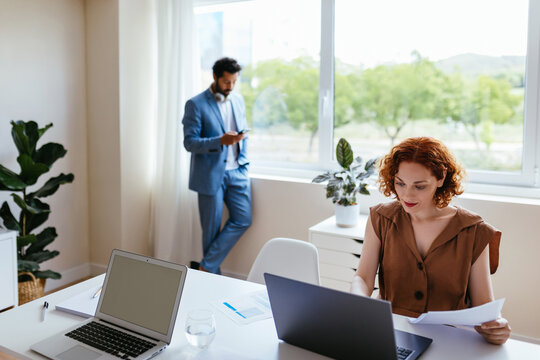Busy woman working in office with colleague