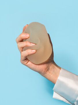 Female hand grabbing a breast implant