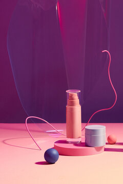 Pink plastic tube for cosmetics on the podium