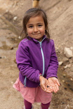 Little girl showing tadpoles to camera