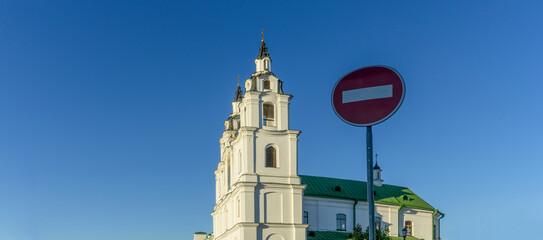 Round traffic sign No entry red and white on the blue sky and orthodox church. Space for text. Stop religion concept.
