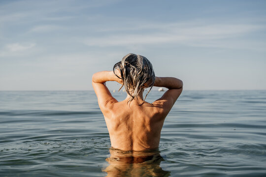 Active mature woman bathing in the sea in the morning