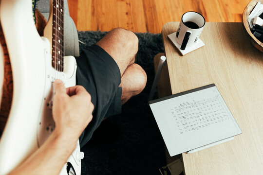 Guy learning how to play guitar.