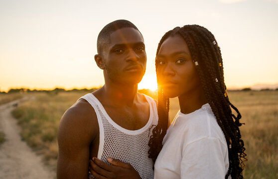 Black Couple On A Field At Sunset.