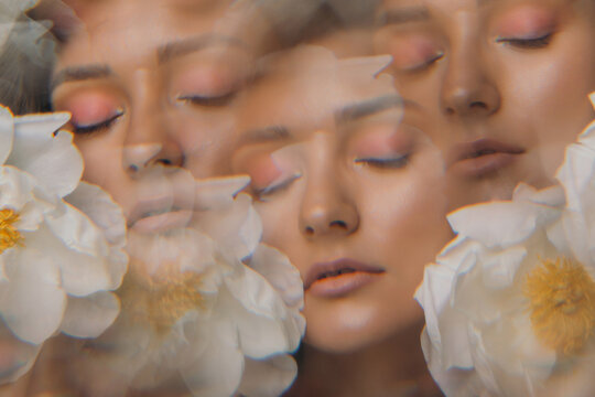 Young woman touching face with flower
