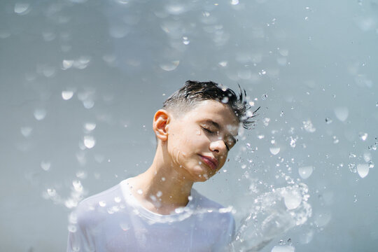 Boy with splash of water on sunlight