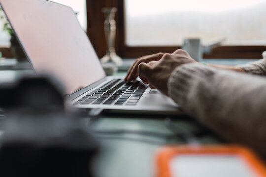 Crop hands using laptop on table
