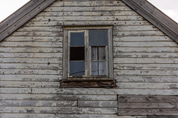 Window of old abandoned white wooden house..