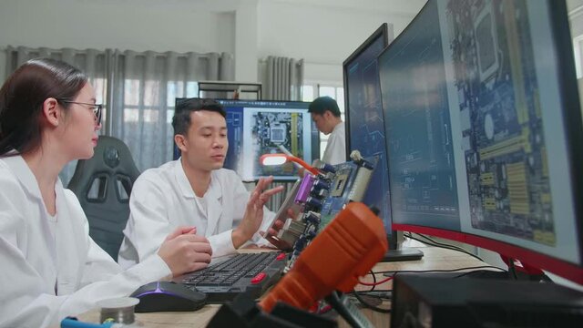 Modern Electronics Development Facility: Asian Team Of Multi Engineers, Scientists Work On Tablet And Computer, Talk, Design Pcb, New Generation Silicon Microchips, Manufacturing Semiconductors
