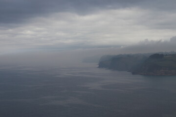 PAISAJE MARINO. TENEBROSO. LLUVIOSO. ATMOSFERA DE MISTERIO. BRUMA SOBRE EL MAR. TONOS OSCUROS. AZUL. NUBES SOBRE EL MAR.