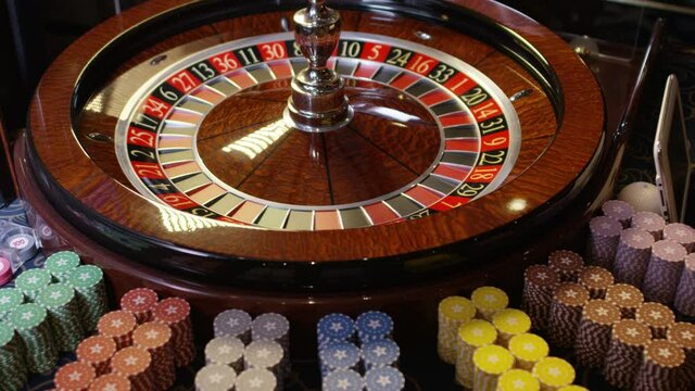 Close up shot of Casino roulette in motion . Spinning wheel ball . Gambling and casino concept with playing chips . Shot on RED EPIC DRAGON Cinema Camera in slow motion with camera move