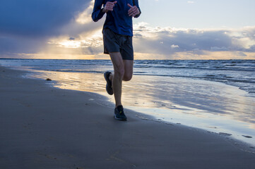 Exercising outside. A jogger in lightweight blue long sleeve t-shirt, shorts and running sneakers...