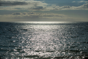 Summer sea background. Texture of water surface. Shining blue water ripple pattern.