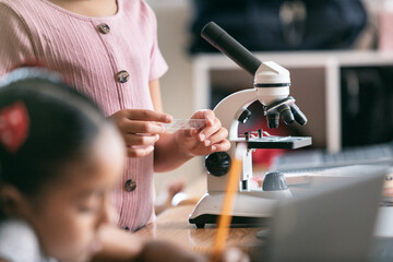 School: Girl Student Uses Microscope And Takes Notes