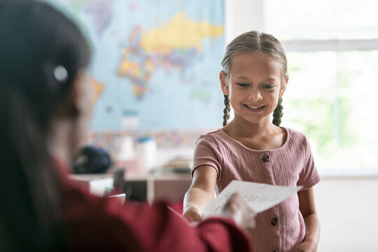 School: Young Girl Student Turning In Test