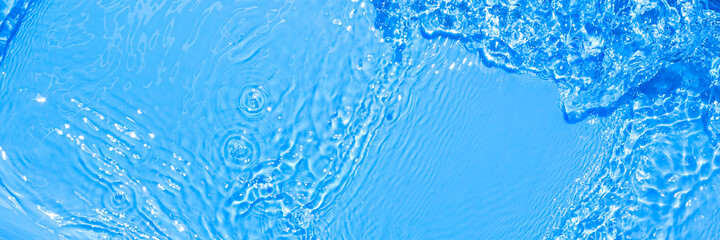 Surface of blue swimming pool water with light reflection. Texture of transparent blue water with ripples and waves in swimming pool. Trendy abstract nature background.