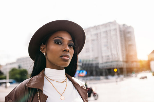 Serious black woman in leather coat and hat