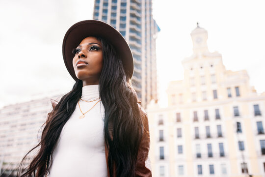 Serious black woman in leather coat and hat