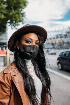 Serious black woman in leather coat and hat