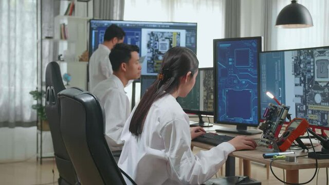 Modern Electronics Development Facility: Asian Engineer And Team Of Multi Scientists Work On Computers, Design Industrial Pcb, New Generation Silicon Microchips, Semiconductors
