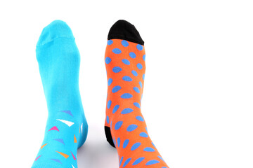 Legs with different a pair of mismatched socks on white background. World Down syndrome day...