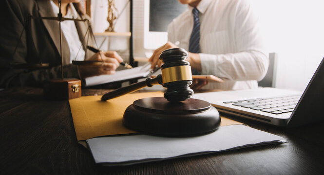 Business and lawyers discussing contract papers with brass scale on desk in office. Law, legal services, advice, justice and law concept picture with film grain effect
