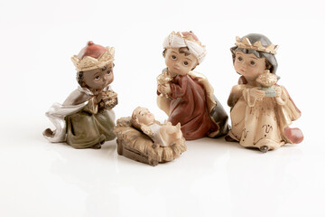 The three wise boys and baby Jesus. Happy Epiphany day concept. Ceramic figures isolated on white...