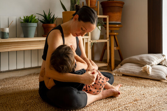 Modern mother feeding her baby at home