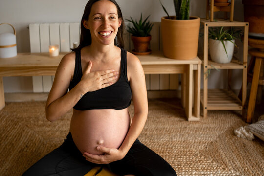Portrait of joyful pregnant woman relaxing at home