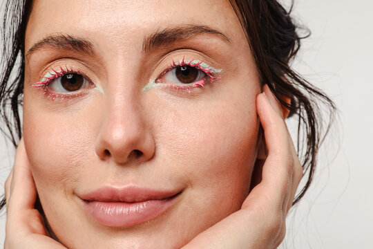 Young woman with green eyeliner and pink mascara