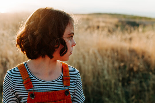 Child looking back profile shot in field.