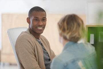 Obraz premium Man and woman sitting in office,smiling and talking