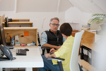 Man and woman sitting in office and talking