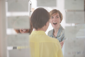 Women talking and smiling in office