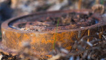 Macro d'un objet circulaire ayant subi les effets de la rouille, dans une forêt. Beaucoup de gens ne font pas attention et se débarrassent de divers objets dans la forêt