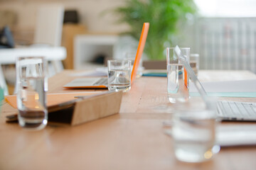 Close up of workplace with laptop and glass on desk