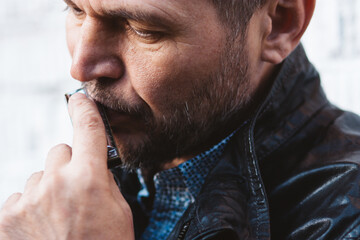 Close up portrait of man playing on harmonica