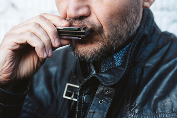 Close up portrait of man playing on harmonica