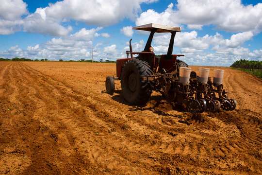 agricultor arando o solo com trator 