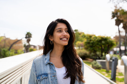 Portrait of happy young woman outdoors looking away