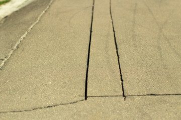 Slots on the asphalt. Sawn asphalt on the road. Two cracks.